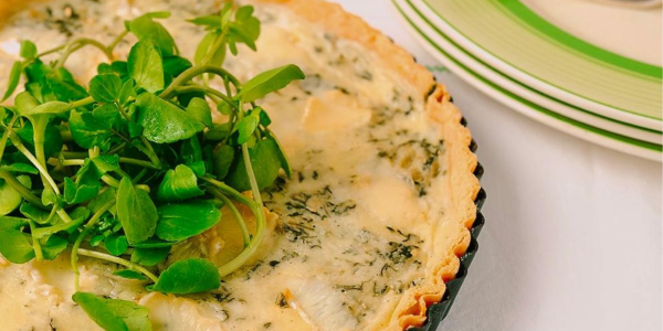 Tunworth and watercress tart fresh from oven with serving plates