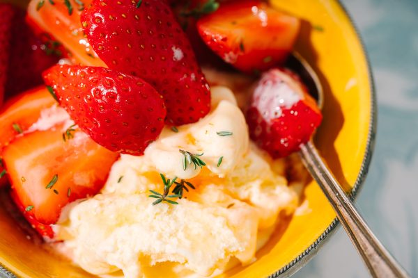 Image shows Tunworth Ice Cream in a bowl with strawberries